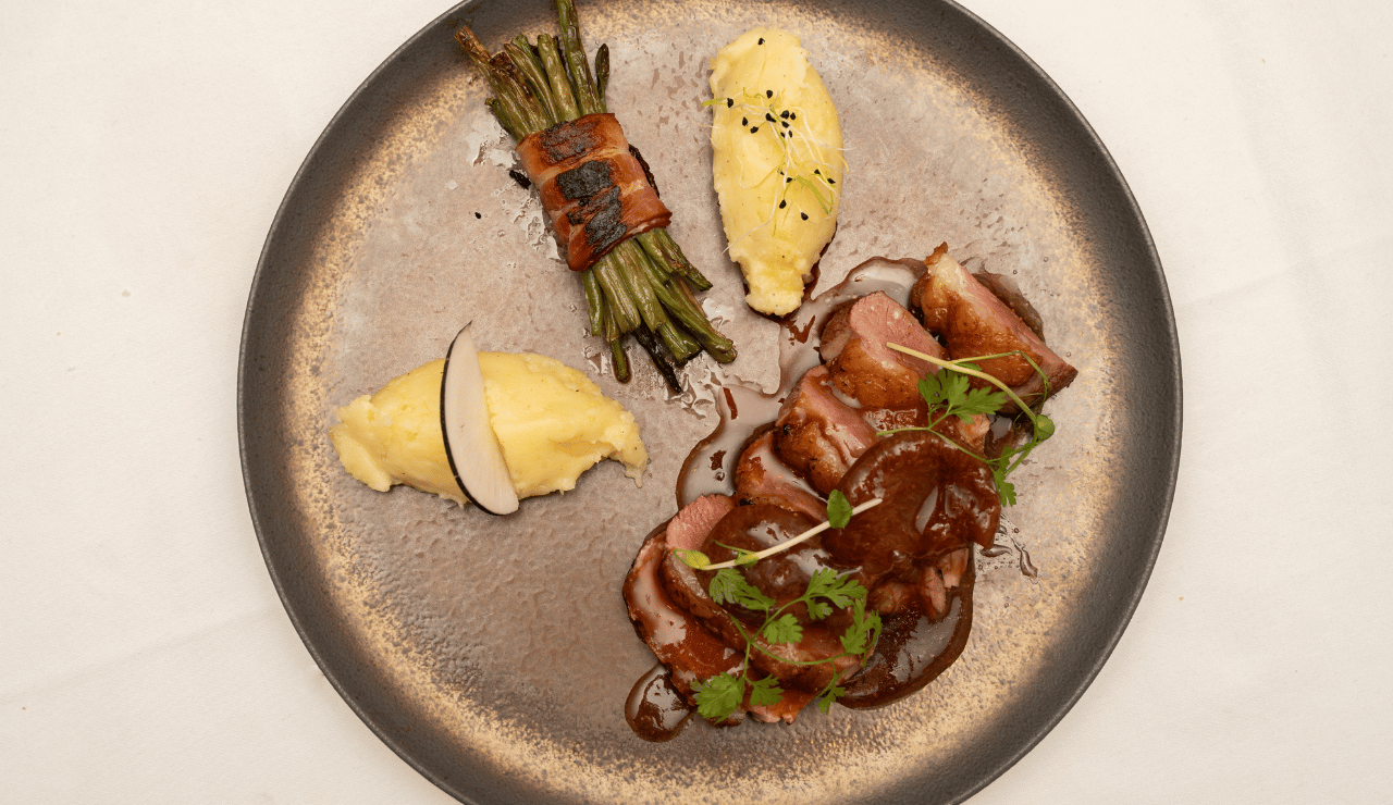 Magret de canard, purée de pommes de terre et haricots verts en fagot lardé.